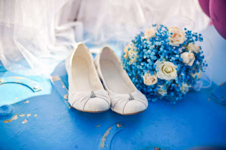 Bridesmaid shoes and blue bouquet Against the background of blue rusty ironの写真素材