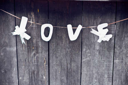 Inscription love on a cord on a background of gray woodの写真素材