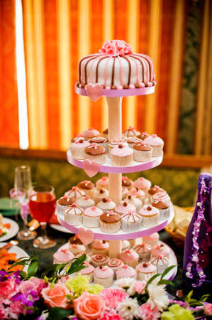 mini cupcakes on a multi level tier pink and brownの写真素材