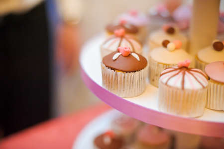 mini cupcakes on a multi level tier pink and brownの写真素材