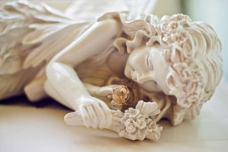 Statue of a sleeping girl and wedding ringsの写真素材