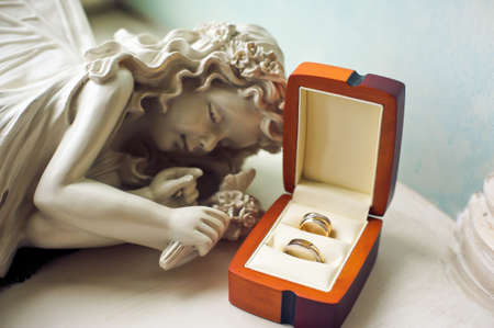 Statue of a sleeping girl and wedding ringsの写真素材
