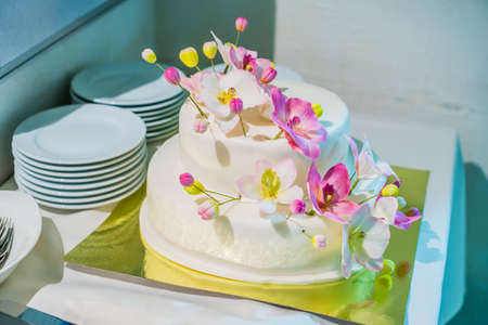 White cake with pink and yellow flowersの写真素材