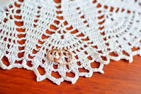 Gold wedding rings on a wooden tableの写真素材