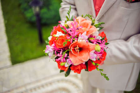Bouquet in the hands of a man in a suitの写真素材
