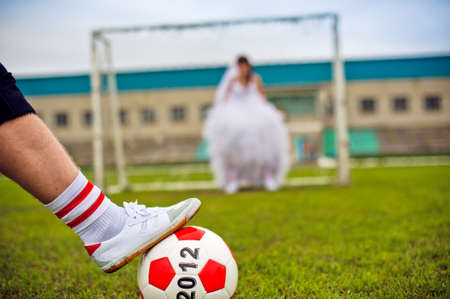 European Football Championship concept. Bride and groom on the football stadium. soccer ball