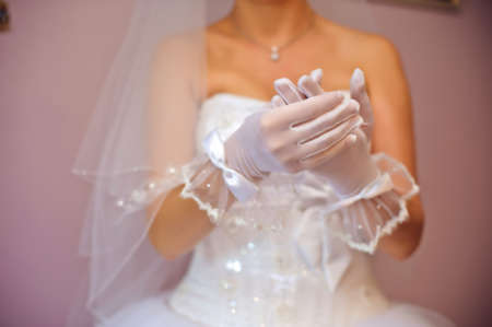 beautiful bride puts on a white gloveの写真素材
