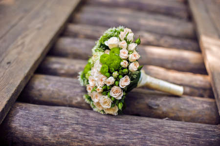 bouquet of flowers and greenery is on wooden logsの写真素材