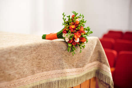 Orange bridal bouquet on a beige tablecloth Wedding conceptの写真素材