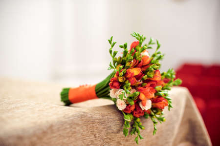 Orange bridal bouquet on a beige tablecloth Wedding conceptの写真素材