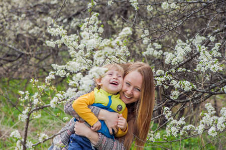 Mother and son, against the background of the cherry blossoms.