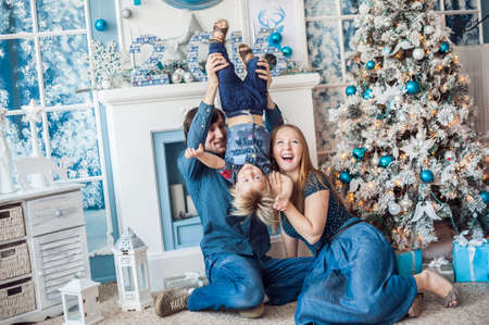 Family sitting by the fireplace and Christmas tree. Christmas conceptの写真素材