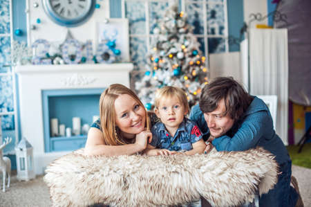 Family sitting by the fireplace and Christmas tree. Christmas conceptの写真素材