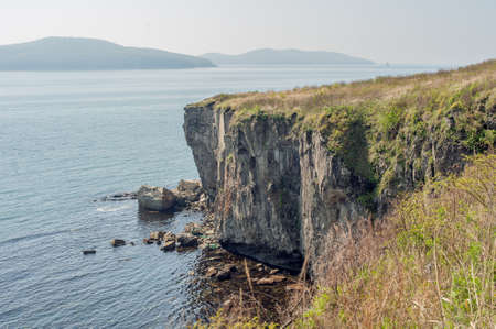 Rocks, cliffs, cold sea spikelets and blue skyの写真素材