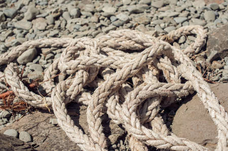 Old marine rope on a rocky seashoreの写真素材