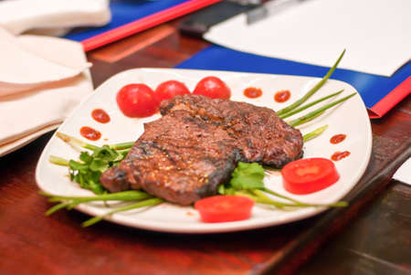 Steak with vegetables on a white plate ready for extradition