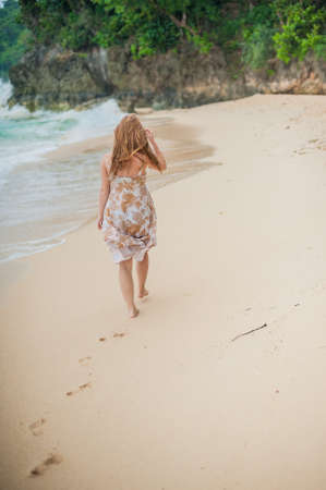 The girl walks on the water's edge on the island of Boracayの写真素材