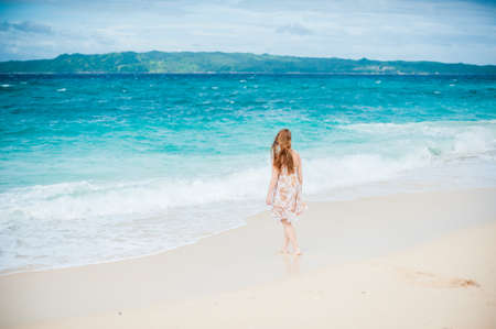 The girl walks on the water's edge on the island of Boracayの写真素材