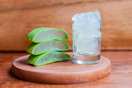 Aloe Vera gel and Aloe leaf cut pieces on a wooden backgroundの写真素材