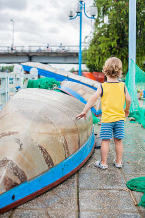 The boy looks at the blue bay with Vietnamese boatの写真素材