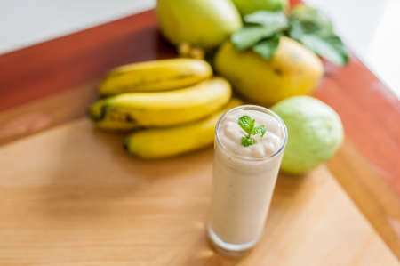 Banana cocktail and fresh bananas on wooden background, proper nutrition conceptの写真素材