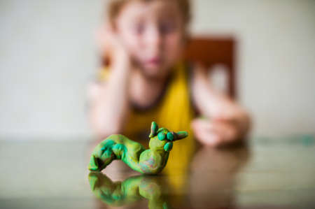 children's creativity. child sculpts from clay.Cute little boy moulds from plasticine on table. Children's creativity conceptの写真素材