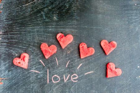 Water melon cut into heart shape. Inscription love with chalk. Flat lay composition. love concept. Valentine's Day Conceptの写真素材