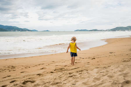 Beach in bad weather. Emptiness, high waves and boy.の写真素材