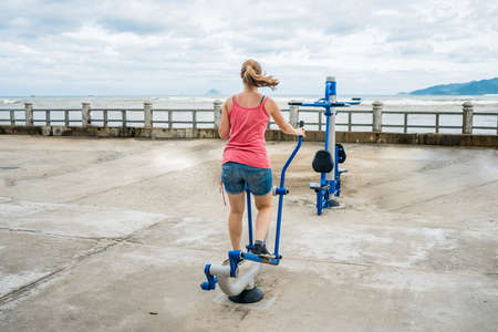 Young woman wanting to lose weight is engaged in the gym on the street