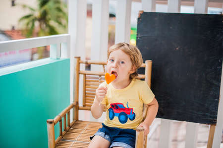 Boy drinking smoothie papaya. Healthy food concept. Black wooden board with space for text.の写真素材