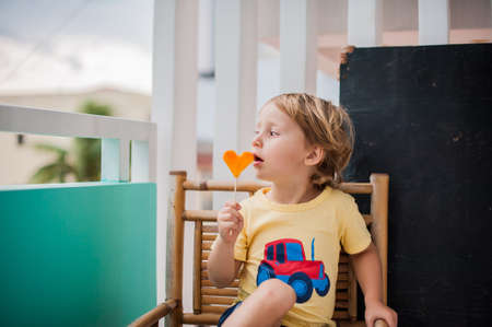 Boy drinking smoothie papaya. Healthy food concept. Black wooden board with space for text.