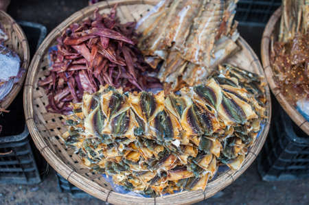 Dried fish on a wicker basket in a market in the Vietnam. Asian food concept.の写真素材