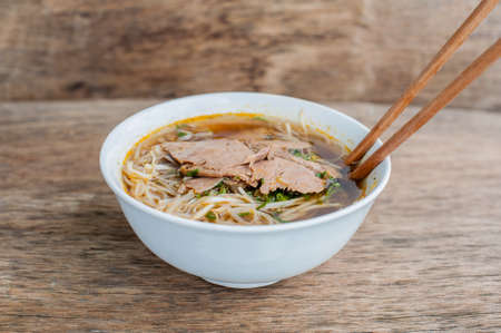 A bowl of Traditional Vietnamese beef soup Pho Bo at the dark old wooden background. ethnic meal. Vietnamese food conceptの写真素材