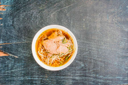 A bowl of Traditional Vietnamese beef soup Pho Bo at the dark old wooden background. ethnic meal. Vietnamese food conceptの写真素材