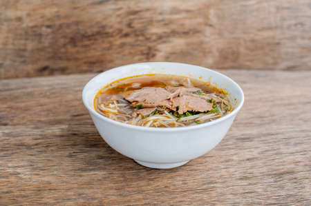 A bowl of Traditional Vietnamese beef soup Pho Bo at the dark old wooden background. ethnic meal. Vietnamese food conceptの写真素材
