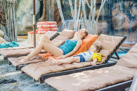 Mother and son relaxing on the sun loungers by the pool. Vacation conceptの写真素材