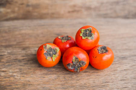 Ripe fresh persimmon on wood board. Food ingredient. Fruitsの写真素材