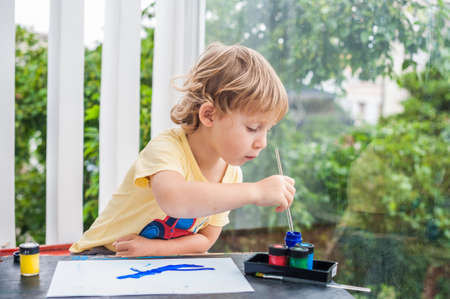 Cute little boy painting with colorful paints. children's creativity and development conceptの写真素材