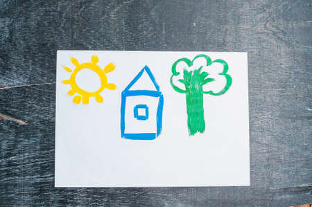 Children's drawing of a house painted with colored paints. Home concept.の写真素材