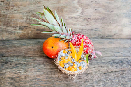 Fruit salad with dragon fruit and papaya in half a coconut. Healthy eating concept. Vegan concept. Tropical fruits conceptの写真素材
