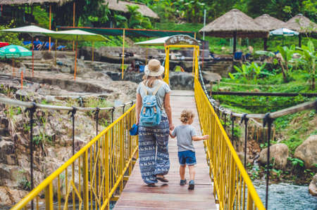 Mother and son are going on a suspension bridge. Traveling with children concept.の写真素材