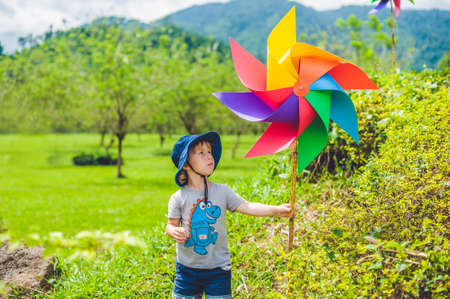 Cute little boy and a pinwheel windmill. the concept of childhood