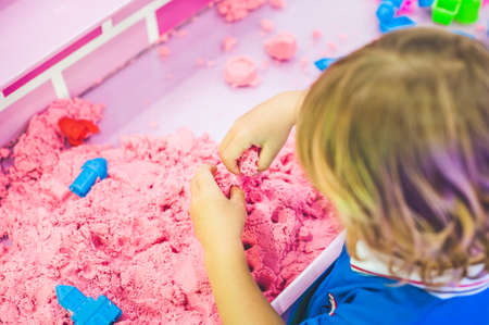 Boy playing with kinetic sand in preschool. The development of fine motor concept. Creativity Game concept.の写真素材