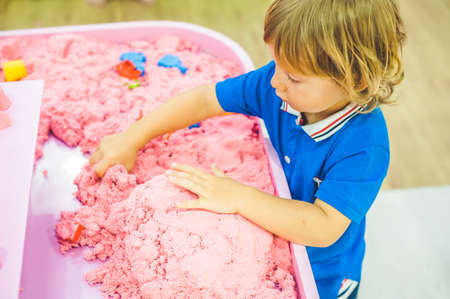 Boy playing with kinetic sand in preschool. The development of fine motor concept. Creativity Game concept.の写真素材
