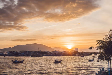 Sunset in Vietnam, sea, small houses and Vietnamese boat.の写真素材