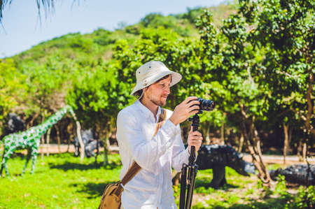 Man shoots at the camera on a tripod in the park. filming concept
