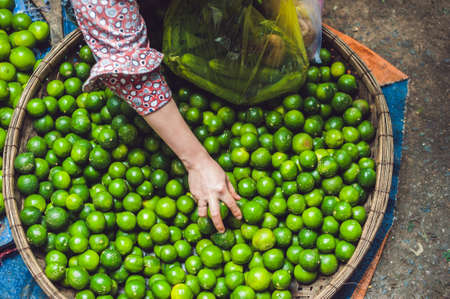 Limes in the wicker basket on the Vietnamese market. Asian food concept.の写真素材