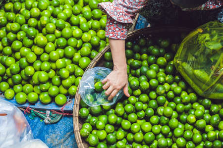 Limes in the wicker basket on the Vietnamese market. Asian food concept.の写真素材