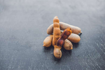 Sweet ripe tamarind pods on old wood background.の写真素材