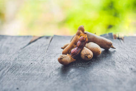 Sweet ripe tamarind pods on old wood background.の写真素材